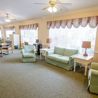 A cozy living room with sofas, chairs, and large windows.