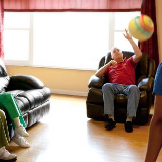 People playing with a ball in a living room.