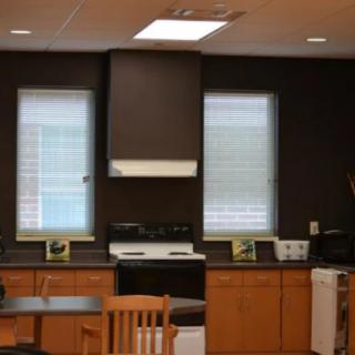 A kitchen interior with a stove, cabinets, and dining area.