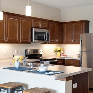 A modern kitchen with wooden cabinets and stainless steel appliances.