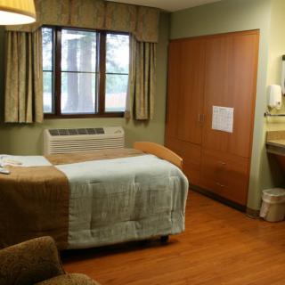 A clean and quiet hospital room with a bed, window, and basic amenities.