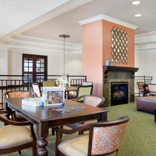 A cozy living room with a fireplace, comfortable seating, and a table for games or conversation.