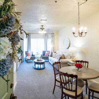 A bright and inviting living space featuring a dining area and comfortable seating arrangements.