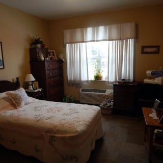 A cozy bedroom with a single bed, window, and various pieces of furniture.