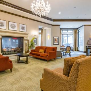 Elegant living room with a cozy seating area, featuring a chandelier and fireplace.