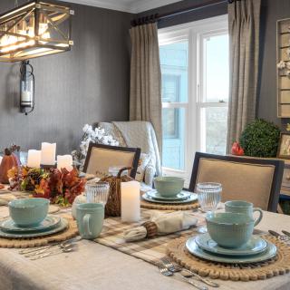 A beautifully decorated dining table with candles and fall-themed decor.