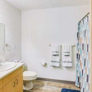 A clean and bright bathroom with a sink, toilet, and patterned shower curtain.