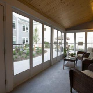 A cozy sunroom with large windows offering a view of the patio.