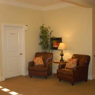 Cozy living room corner with two armchairs, a lamp, and decorative plant.