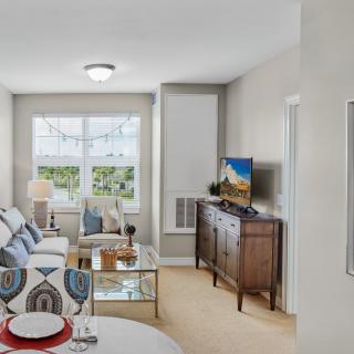 A cozy living room with modern furniture and a large window.
