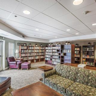 A cozy library reading room with bookshelves and comfortable seating.