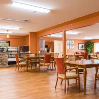 An empty dining area with wooden tables and chairs.