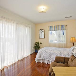A cozy bedroom with hardwood floors and ample natural light.