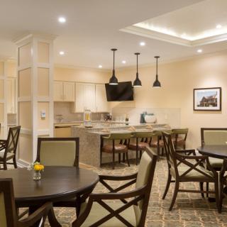 A modern dining area with neatly arranged tables and chairs, complemented by elegant lighting fixtures.