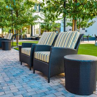 Comfortable outdoor seating area with cushioned chairs on a landscaped patio.