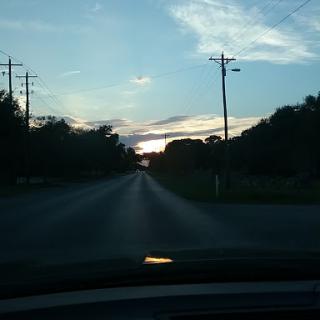 A serene drive at sunset, painting the sky with beautiful hues.