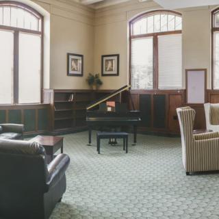 A cozy lounge area with a grand piano and comfortable seating.
