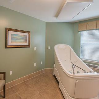 Modern bathroom with a sleek bathtub and green walls.