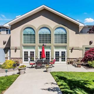 A modern building with arched windows and a patio area set against a clear blue sky.