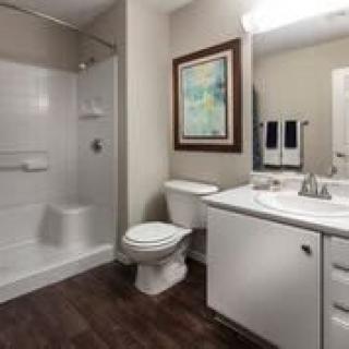 A clean, modern bathroom with a shower, toilet, and sink.