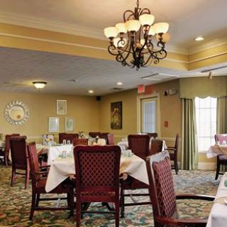 A cozy dining room with elegantly set tables and a chandelier.