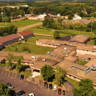 Aerial view of a medical facility surrounded by greenery and a small town.