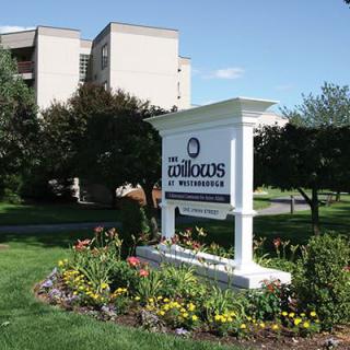 A residential apartment complex sign surrounded by well-maintained gardens.