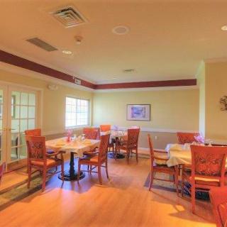 An empty dining room with neatly arranged tables and chairs.
