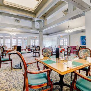 An elegant dining area with classic decor, featuring tables set for guests.