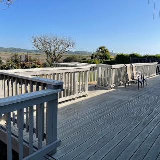 A spacious outdoor deck with furniture and a scenic view under a clear sky.