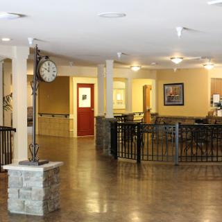 A spacious lobby featuring a wall clock and warm lighting.
