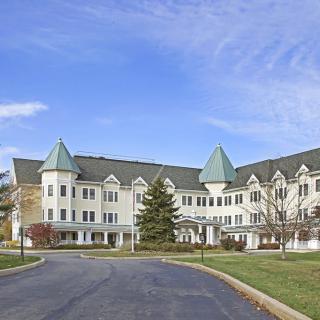 A large residential building with distinct architectural features and a clear sky backdrop.