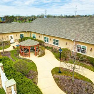 Aerial view of a building with a landscaped garden and winding pathways.
