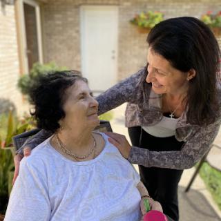 A joyful moment shared between a caregiver and an elderly woman, filled with warmth and connection.