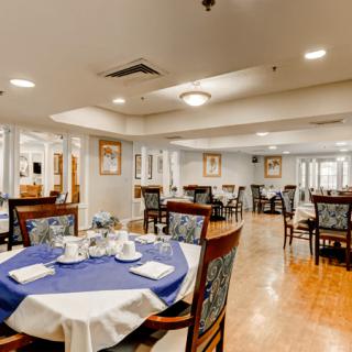 A spacious dining room with elegantly set tables and comfortable seating.