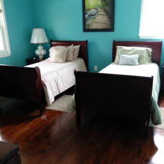 A cozy bedroom with two twin beds and teal walls.