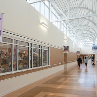 A well-lit interior hallway featuring decorative banners and people walking through a commercial space.