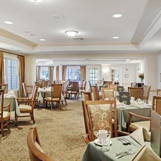 A well-lit dining area with neatly arranged tables and chairs, adorned with elegant table settings.