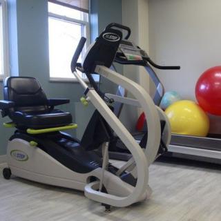 A well-equipped gym features an elliptical machine, offering a space for fitness and rehabilitation exercises indoors.