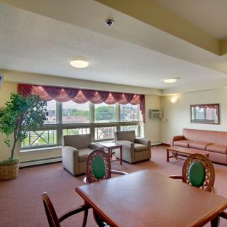 A cozy living room with ample seating, large windows, and natural light.
