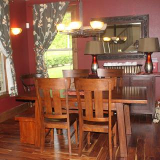 A cozy dining room with wooden furniture and warm lighting.
