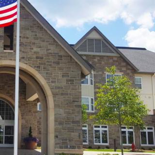 A building with a stone facade and an American flag at the entrance.