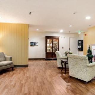 A cozy lobby area with armchairs and a wooden floor, featuring warm lighting and decorative elements.