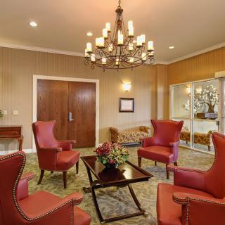 A cozy lobby area with elegant armchairs and a decorative chandelier.