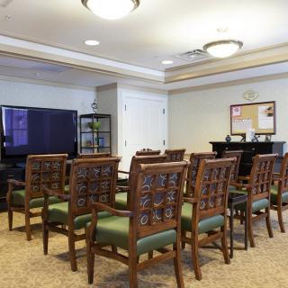 A well-arranged conference room with chairs facing a television screen.