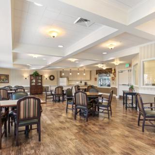 A spacious and well-lit dining area with wooden floors and comfortable seating.