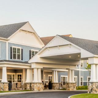 A large residential building with a grand entrance and driveway.