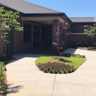 A well-maintained entrance featuring a landscaped garden and a winding pathway leading to the building.