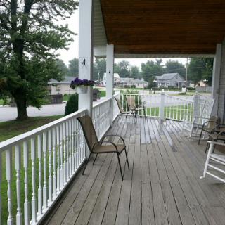 A quiet porch with chairs overlooking a rainy neighborhood.
