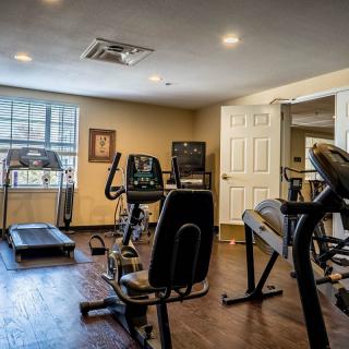 A home gym equipped with various exercise machines including a treadmill, stationary bike, and elliptical.